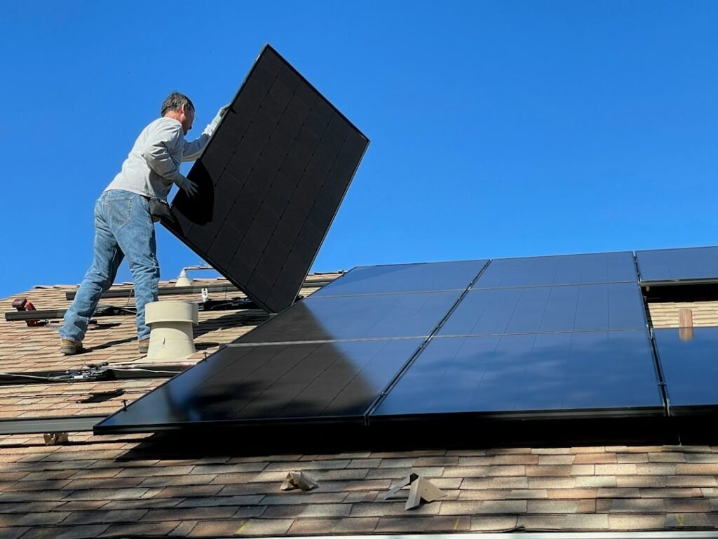 Worker installing rooftop solar panels